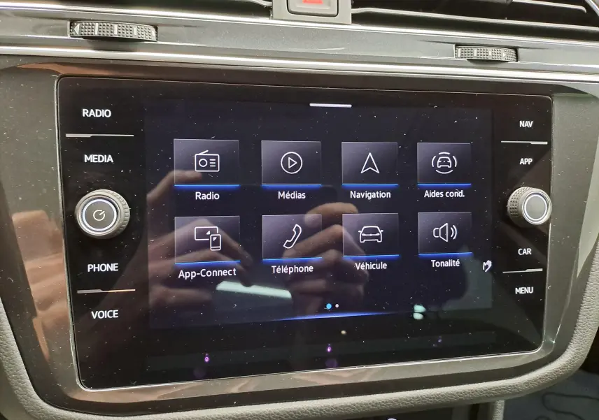 Écran tactile central du Volkswagen Tiguan 2022 affichant les options radio, médias, navigation et aides à la conduite.