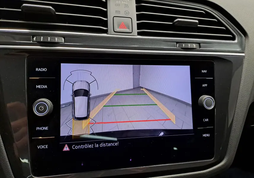 Écran central du Volkswagen Tiguan 2022 affichant la caméra de recul avec guidage de trajectoire et alerte de distance.