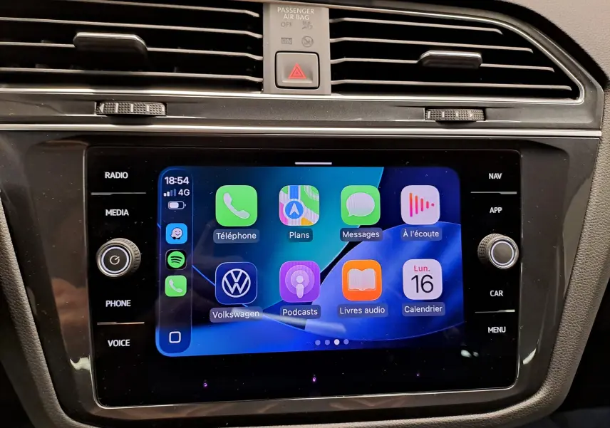 Écran tactile central du Volkswagen Tiguan 2022 affichant les applications connectées, avec commandes autour et finition noire.