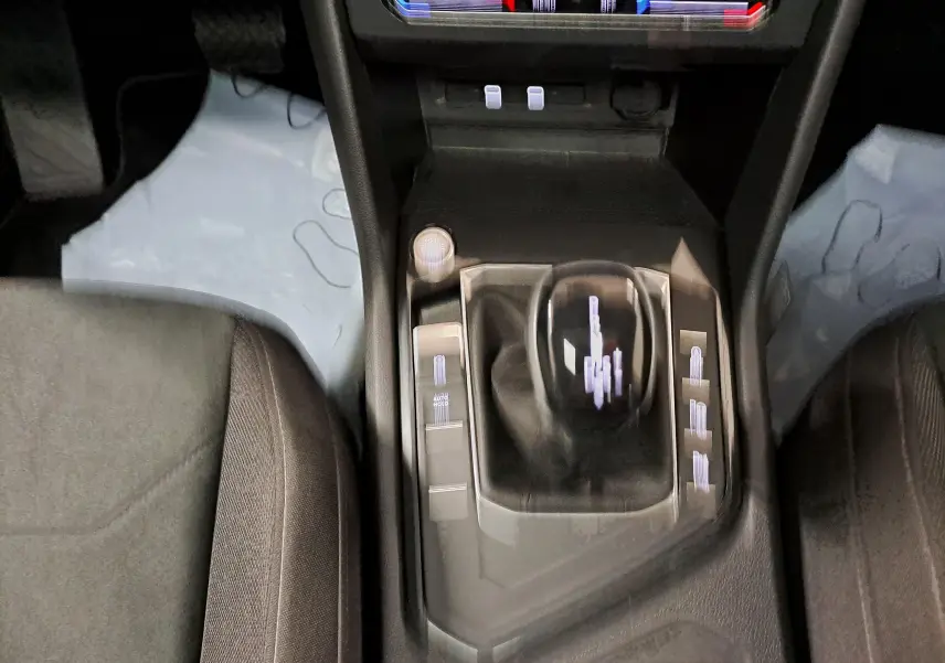 Vue rapprochée de la console centrale du Volkswagen Tiguan 2022, avec levier de boîte automatique et bouton start/stop.