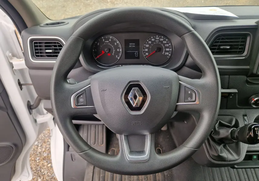 Vue rapprochée du volant noir de Renault Master blanc 2020, avec tableau de bord et levier de vitesses manuelle visibles.