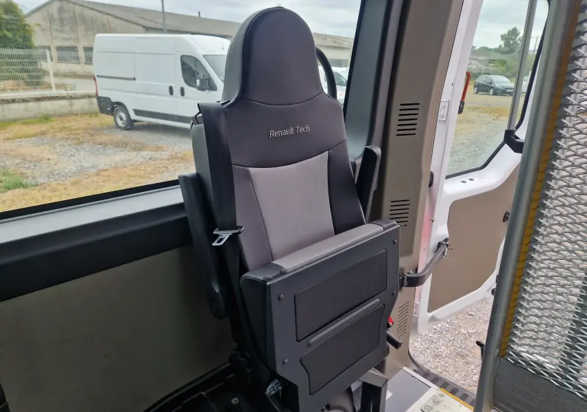 Siège passager rabattable gris Renault Tech à l'intérieur d'un Renault Master blanc, vue côté porte latérale ouverte.
