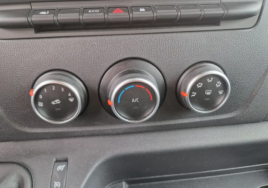 Gros plan sur les commandes de climatisation du tableau de bord du Renault Master blanc, version 2020 TPMR.