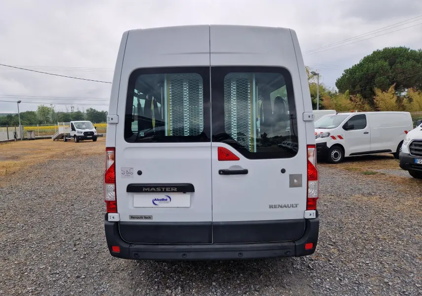 Vue arrière d’un Renault Master blanc 2020 avec portes vitrées et rampe d’accès pour fauteuil roulant.