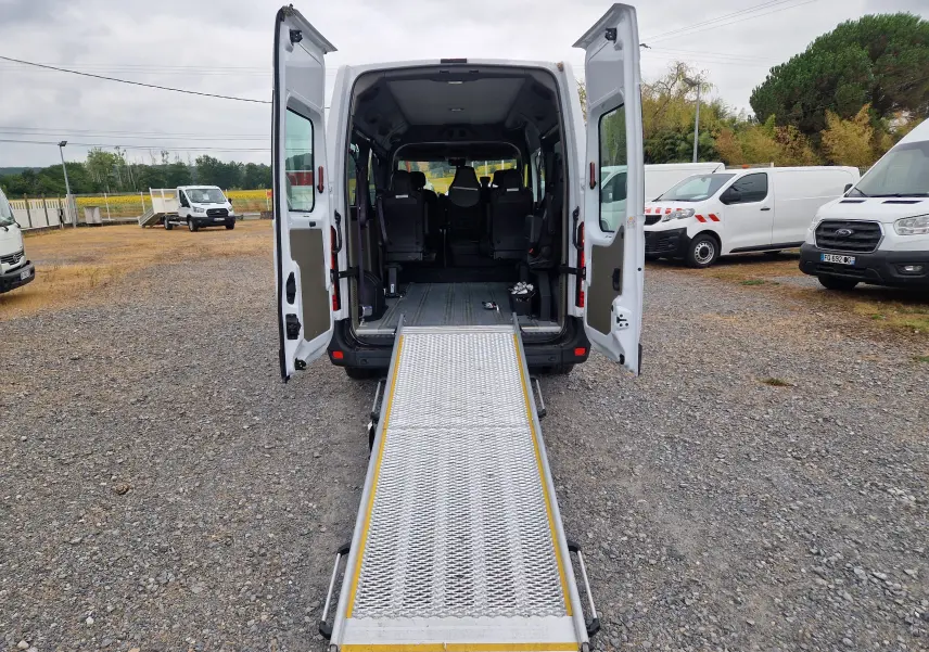 Vue arrière d’un Renault Master blanc 2020 avec portes ouvertes et rampe d’accès déployée pour fauteuil roulant.