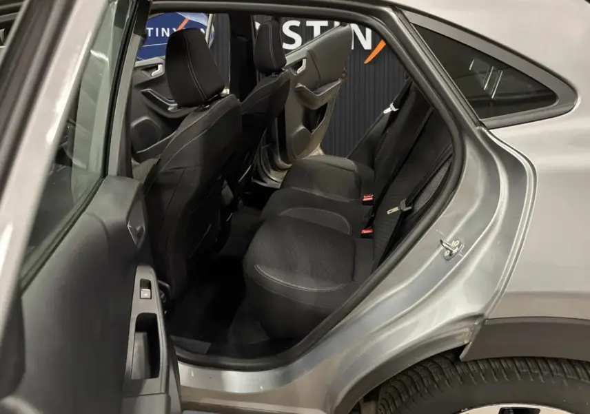 Vue côté gauche arrière du Ford Puma gris Solar 2023, montrant l'intérieur avec sièges arrière en tissu noir.