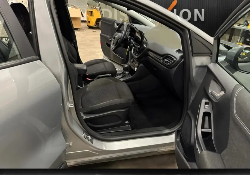 Vue intérieure côté conducteur du Ford Puma gris solar 2023, montrant sièges noirs et tableau de bord moderne.