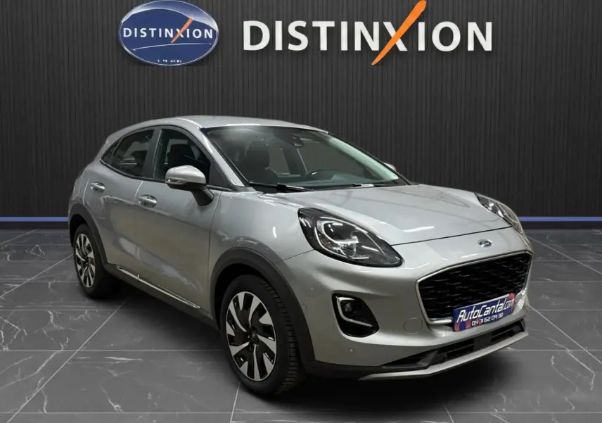 Ford Puma gris solar en 3/4 avant droit, mettant en valeur ses phares LED et sa calandre noire distinctive.
