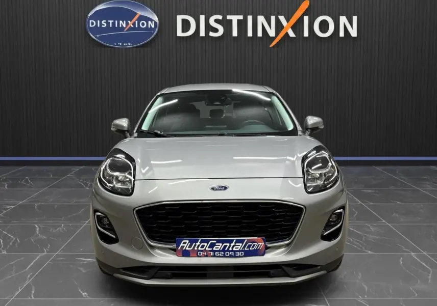 Vue frontale d'un Ford Puma gris solar 2023 avec calandre noire et phares LED, en showroom Distinxion.