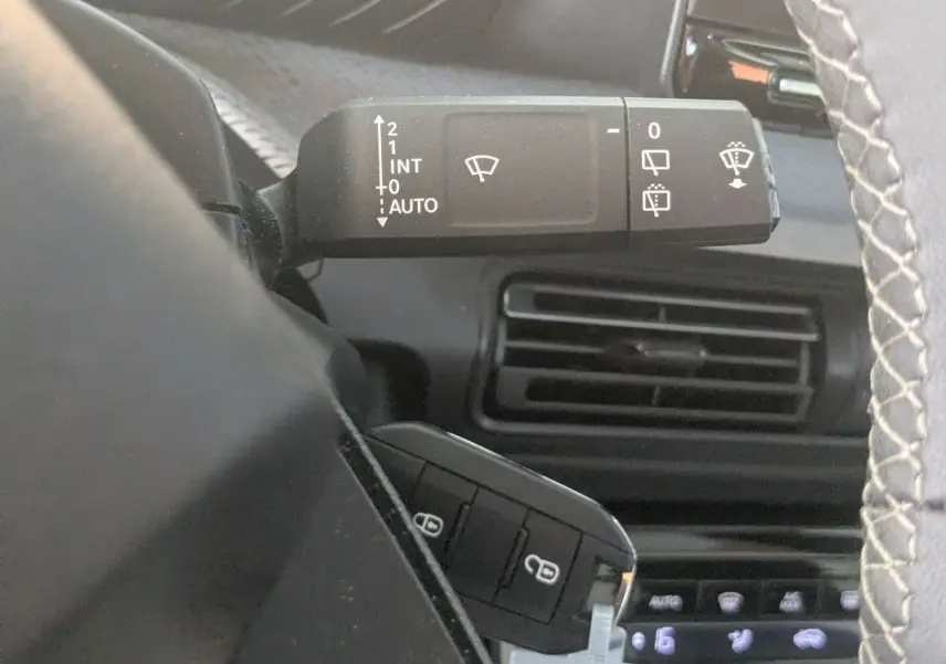 Gros plan sur la commande d'essuie-glace et la ventilation intérieure du Citroën E-C3 Aircross 2025 noir.