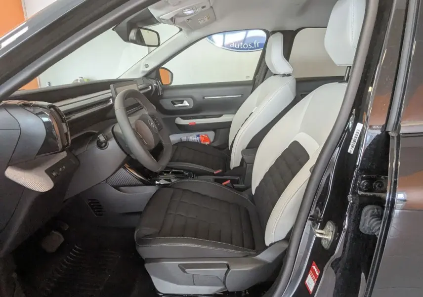Intérieur avant droit du Citroën E-C3 Aircross 2025 noir, sellerie bicolore TEP/tissu avec tableau de bord moderne.