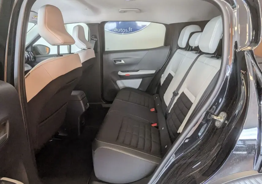 Vue intérieure côté droit montrant la banquette arrière bicolore noire et beige du Citroën E-C3 Aircross noir 2025.