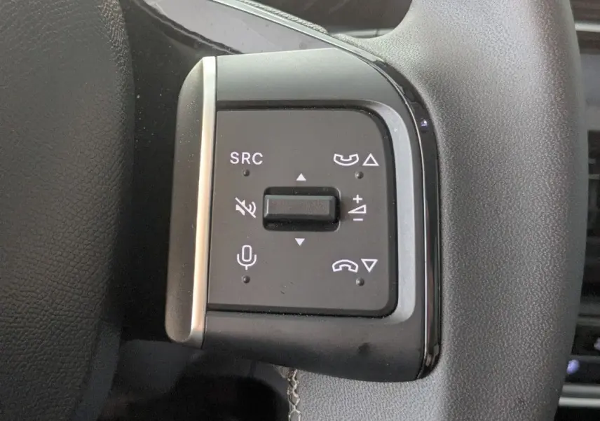 Gros plan sur les commandes de volume et téléphone au volant du Citroën E-C3 Aircross noir 2025.