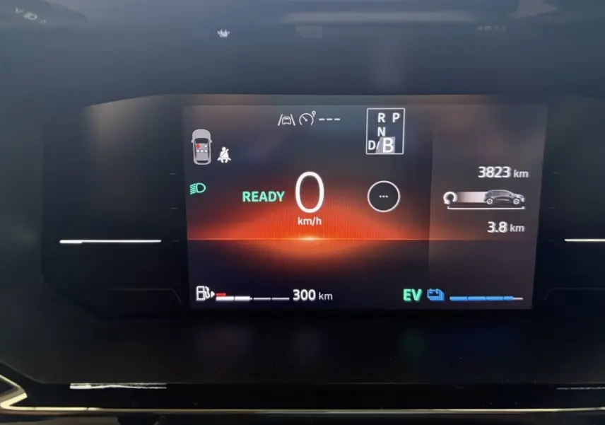 Affichage numérique du tableau de bord de la Renault Clio 2025 rouge, montrant la vitesse à 0 km/h et l'autonomie hybride.