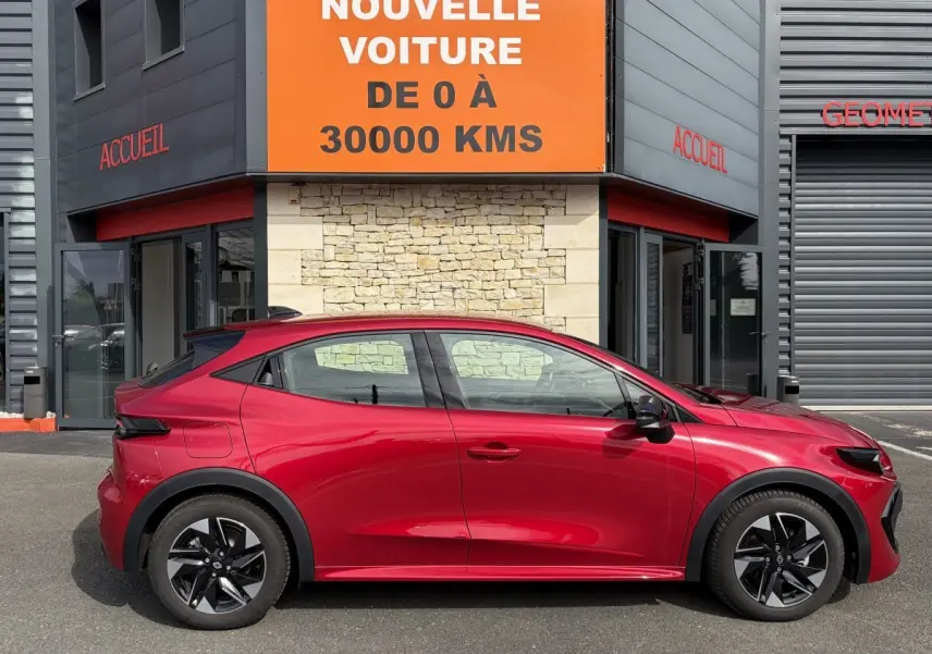 Profil côté gauche de la Renault Clio Evolution rouge 2025, hybride essence, avec jantes noires distinctives.