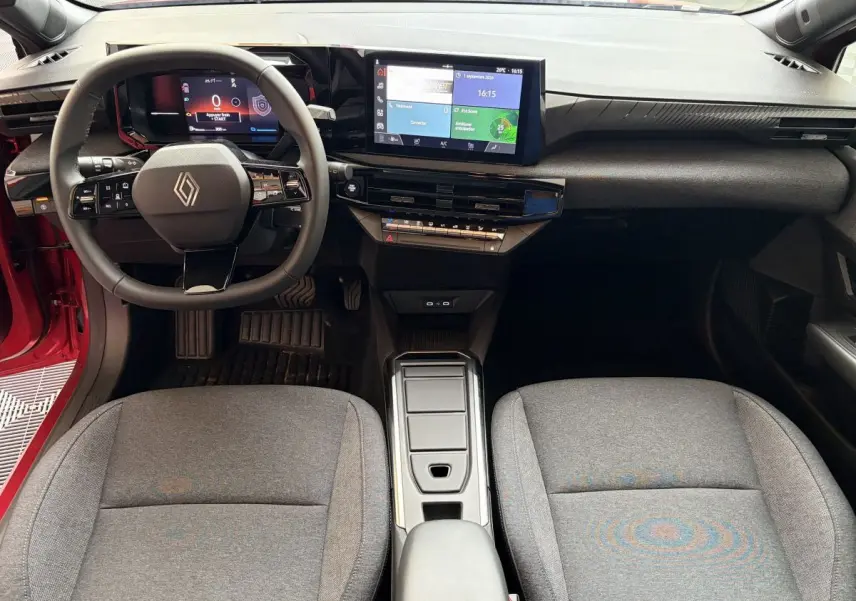 Vue intérieure avant de la Renault Clio 2025 rouge, avec tableau de bord numérique et écran tactile central.