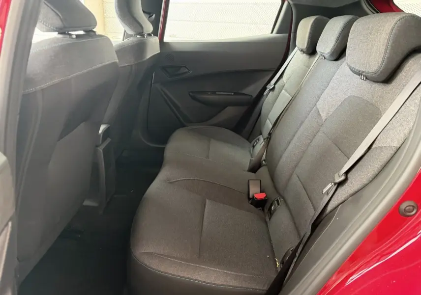 Vue intérieure côté droit sur la banquette arrière grise de la Renault Clio rouge 2025 hybride E-Tech.