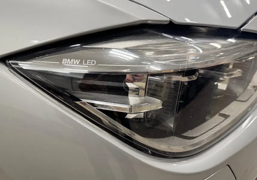 Gros plan sur le phare avant droit LED d’une BMW Série 3 Touring F31 gris aluminium, mettant en valeur le marquage BMW LED.