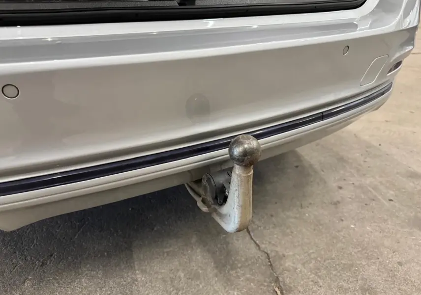 Gros plan sur l'attelage électrique arrière d'une BMW Série 3 Touring F31 gris aluminium, avec pare-chocs visible.