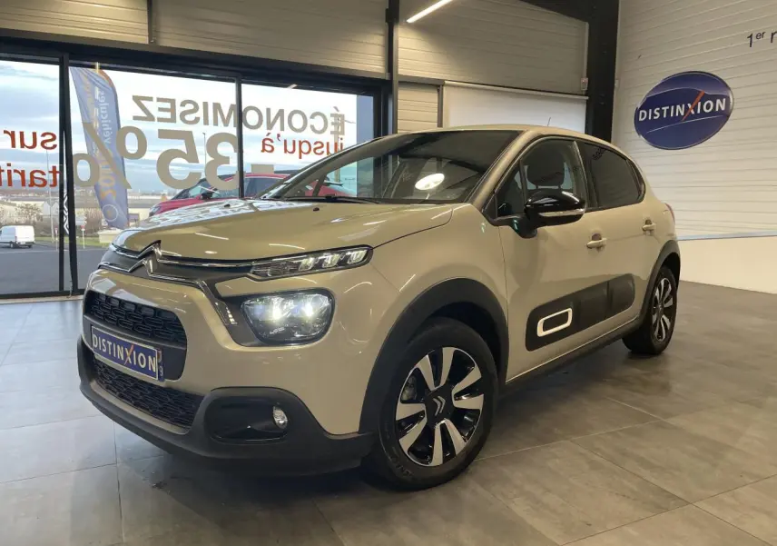 Citroën C3 beige clair vue 3/4 avant droit en intérieur, avec Airbump noir et jantes alliage bicolores.