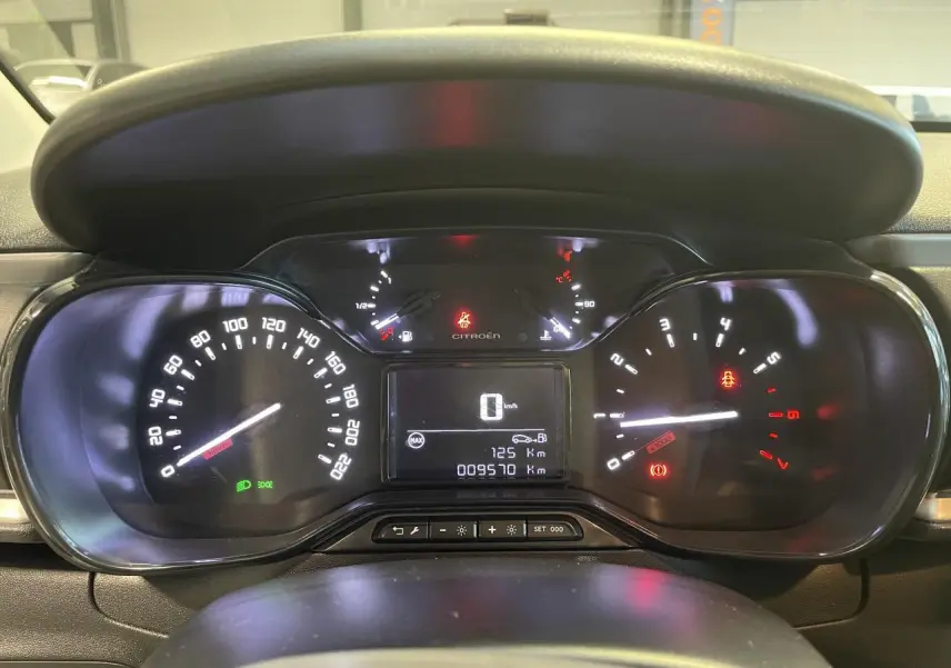 Vue rapprochée du tableau de bord numérique de la Citroën C3 2024 avec compteurs éclairés et affichage central.