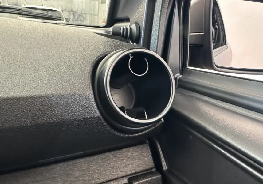 Détail de la console intérieure côté conducteur avec prise ronde et rétroviseur extérieur caméra sur Aixam Ambition bleu 2026.