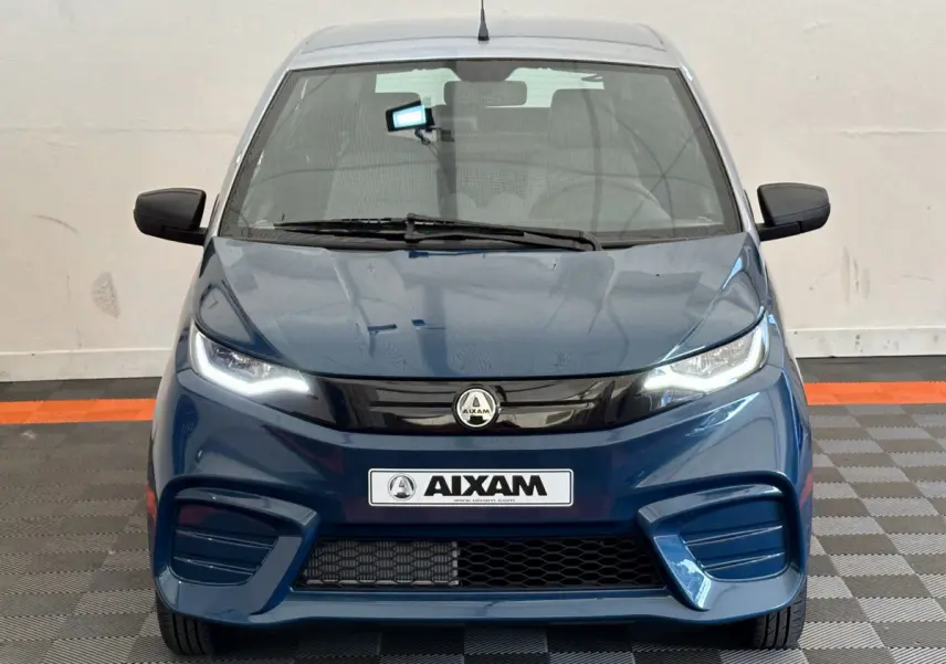 Vue frontale d'une Aixam Ambition 0.5 City Pack bleu 2026 avec phares LED et calandre noire brillante.