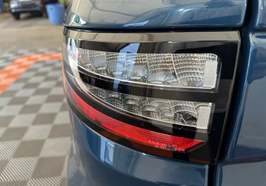 Gros plan sur le feu arrière droit bleu de l'AIXAM AMBITION 0.5 CITY PACK 2026 avec détails lumineux distinctifs.