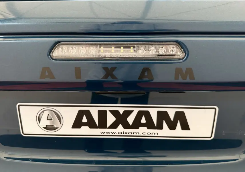 Gros plan sur l'arrière bleu d'une Aixam Ambition 0.5 City Pack avec feu stop et logo AIXAM visible.
