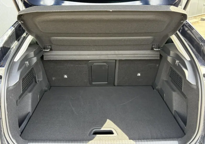 Coffre ouvert vu de l'arrière d'une Citroën C4 Hybrid 145 bleu Eclipse, montrant un espace de chargement propre et spacieux.