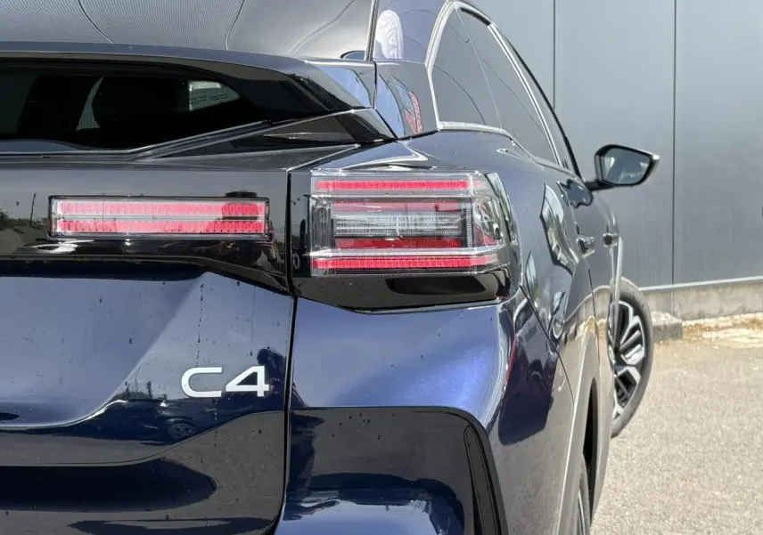 Vue arrière droite du Citroën C4 Hybrid 2025 en Bleu Eclipse avec feux LED et jantes alliage visibles.