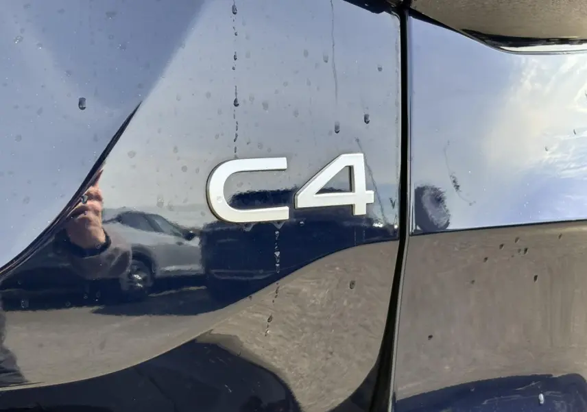 Détail de l'arrière gauche bleu Eclipse d'une Citroën C4 avec logo C4 en relief argenté.