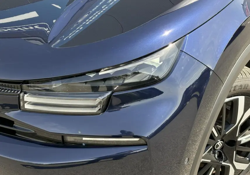 Gros plan sur l'avant droit bleu Eclipse du Citroën C4 Hybrid 2025 avec phares LED et jante alliage 18 pouces.