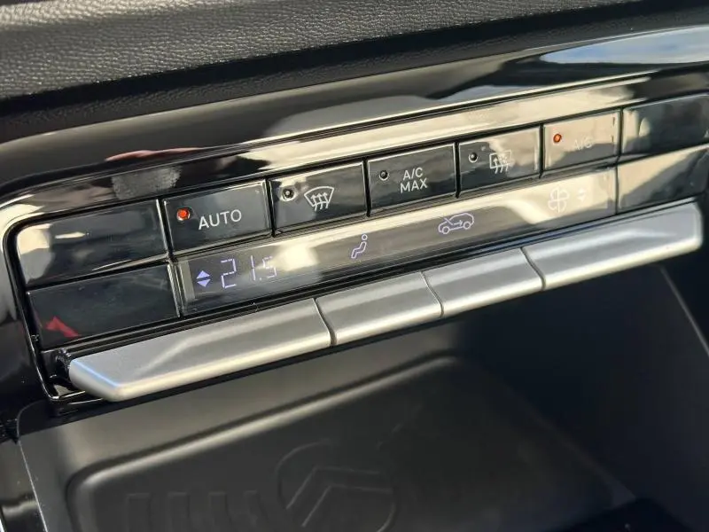 Gros plan sur les commandes de climatisation automatique avec affichage digital dans le Citroën C3 Aircross noir.