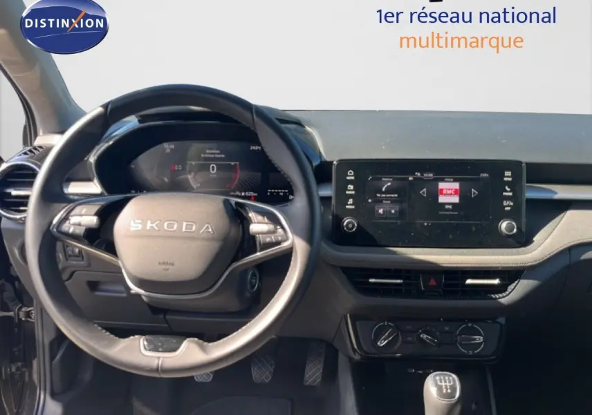 Vue intérieure frontale du tableau de bord de la Skoda Fabia noire, avec volant multifonction et écran tactile central.