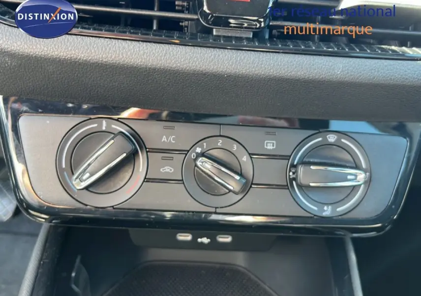 Gros plan sur les commandes manuelles de climatisation de la Skoda Fabia noire, avec boutons rotatifs et ports USB visibles en dessous.