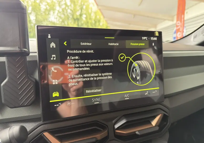 Écran tactile intérieur du DACIA BIGSTER Hybrid 155 Extreme affichant la procédure de réinitialisation de la pression des pneus.