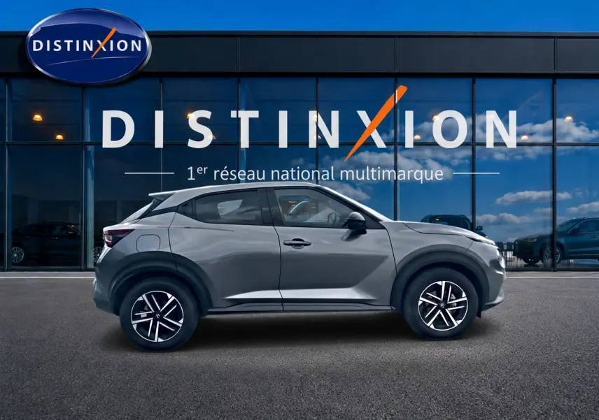 Vue de profil côté gauche d'un Nissan Juke gris 2025 avec jantes alliage et boucliers ton carrosserie.