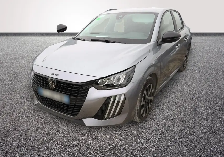 Peugeot 208 gris clair vue 3/4 avant droit, avec calandre noire et feux LED distinctifs en forme de griffes.