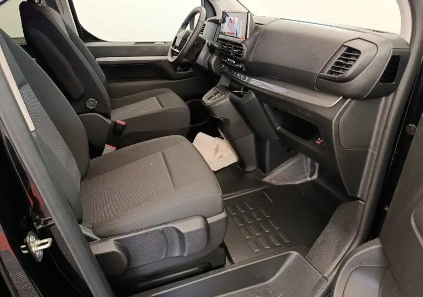 Vue intérieure côté passager avant du Peugeot Expert Fourgon noir, montrant les sièges et le tableau de bord moderne avec écran tactile.