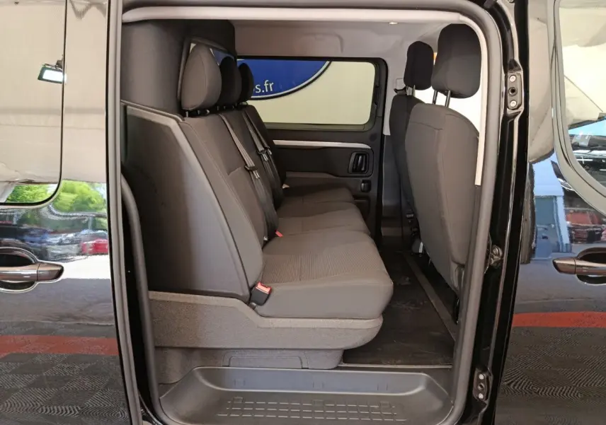 Vue latérale intérieure du Peugeot Expert Fourgon XL noir, montrant la banquette arrière 3 places et les portes coulissantes ouvertes.