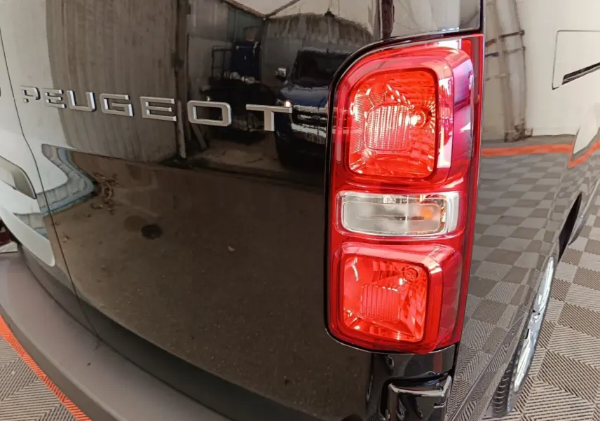 Gros plan sur le feu arrière droit d’un Peugeot Expert Fourgon XL noir, avec logo Peugeot visible sur la porte arrière.