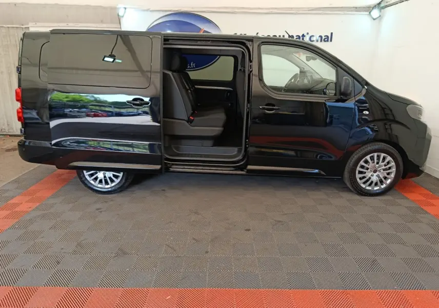 Vue latérale gauche du Peugeot Expert Fourgon XL noir avec porte coulissante ouverte montrant les sièges avant.