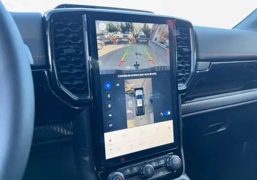 Vue intérieure centrée sur l'écran tactile 12 pouces du Ford Ranger Wildtrak noir agate, affichant la caméra 360° et aides au stationnement.