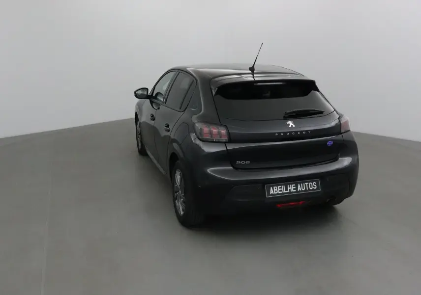 Vue 3/4 arrière d'une Peugeot 208 noire 2022 avec feux arrière distinctifs et antenne de toit visible.