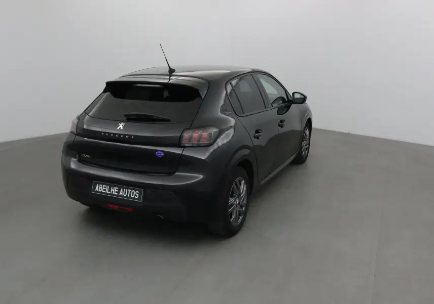 Vue 3/4 arrière droite d'une Peugeot 208 noire 2022 avec feux arrière caractéristiques et antenne sur le toit.