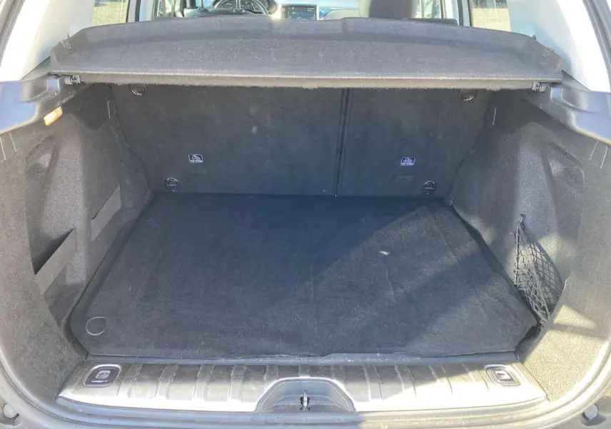 Coffre ouvert de la Peugeot 2008 2019, vue arrière, montrant un espace de chargement noir avec cache-bagages en place.