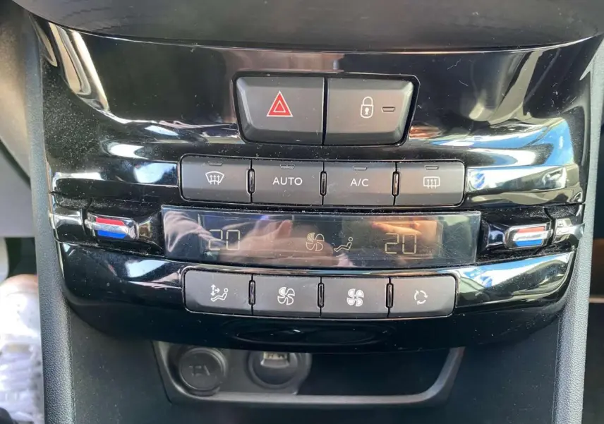 Vue rapprochée de la console centrale noire du Peugeot 2008 2019 avec commandes climatisation automatique bi-zone.