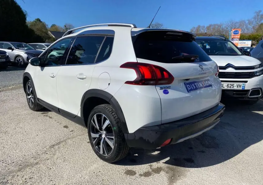 Vue 3/4 arrière droite d'un Peugeot 2008 blanc avec jantes alliage 17'' et vitres arrière surteintées.
