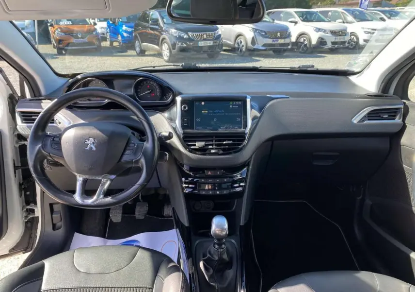 Vue intérieure avant du tableau de bord et volant cuir de la Peugeot 2008 1.2i 12V S&S 130 Allure avec écran tactile central.